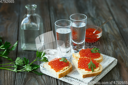 Image of Vodka and traditional snack on wooden background