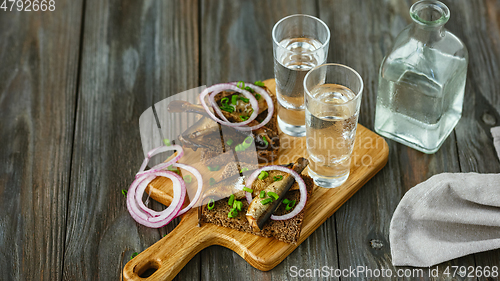 Image of Vodka and traditional snack on wooden background