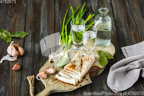 Image of Vodka and traditional snack on wooden background