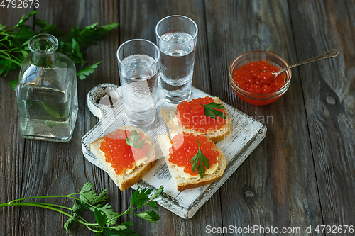 Image of Vodka and traditional snack on wooden background