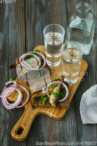 Image of Vodka and traditional snack on wooden background