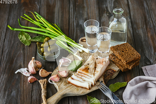 Image of Vodka and traditional snack on wooden background