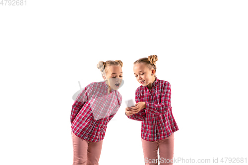 Image of Young handsome girl arguing with herself on white studio background.