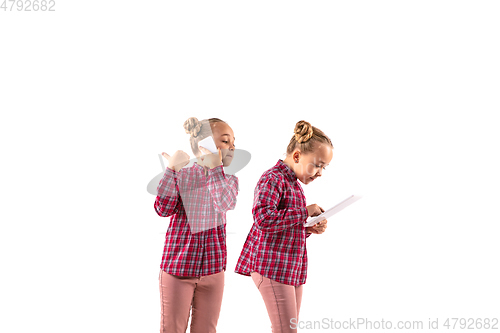 Image of Young handsome girl arguing with herself on white studio background.