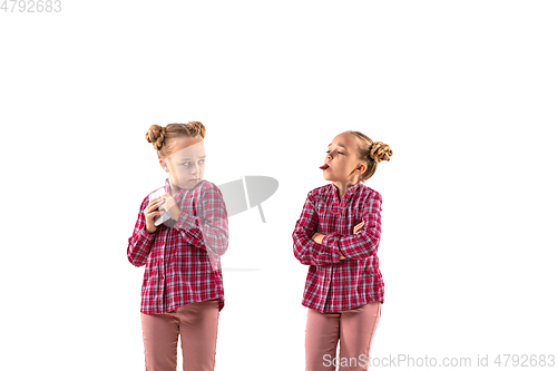 Image of Young handsome girl arguing with herself on white studio background.