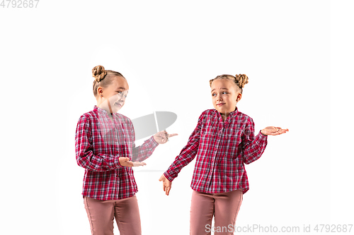 Image of Young handsome girl arguing with herself on white studio background.