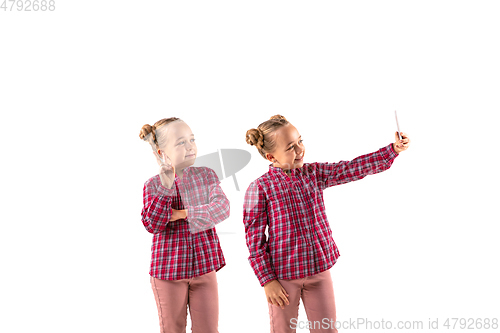 Image of Young handsome girl arguing with herself on white studio background.