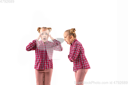 Image of Young handsome girl arguing with herself on white studio background.