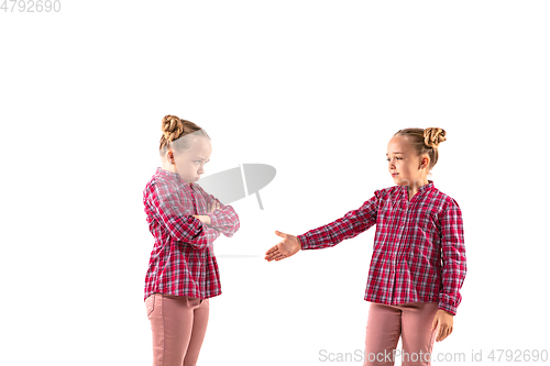 Image of Young handsome girl arguing with herself on white studio background.