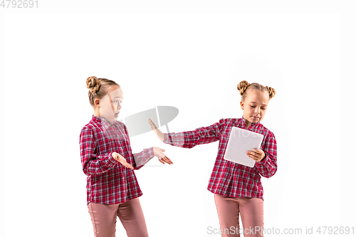 Image of Young handsome girl arguing with herself on white studio background.