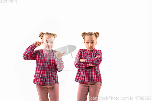 Image of Young handsome girl arguing with herself on white studio background.