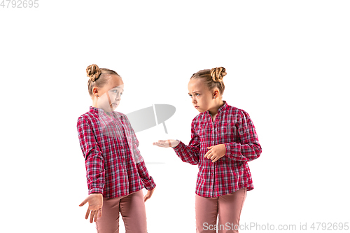 Image of Young handsome girl arguing with herself on white studio background.