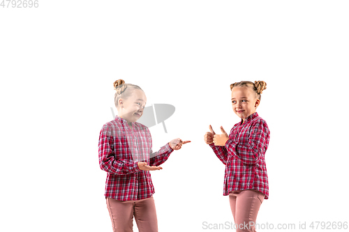 Image of Young handsome girl arguing with herself on white studio background.