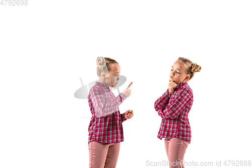 Image of Young handsome girl arguing with herself on white studio background.