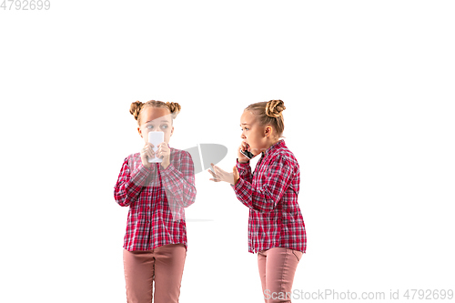 Image of Young handsome girl arguing with herself on white studio background.