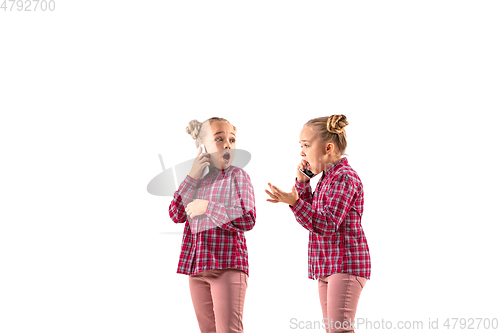 Image of Young handsome girl arguing with herself on white studio background.