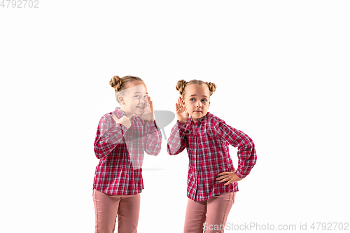 Image of Young handsome girl arguing with herself on white studio background.