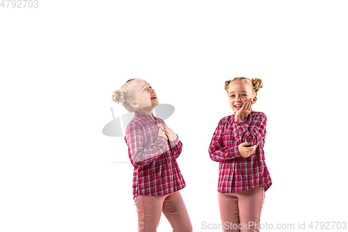 Image of Young handsome girl arguing with herself on white studio background.