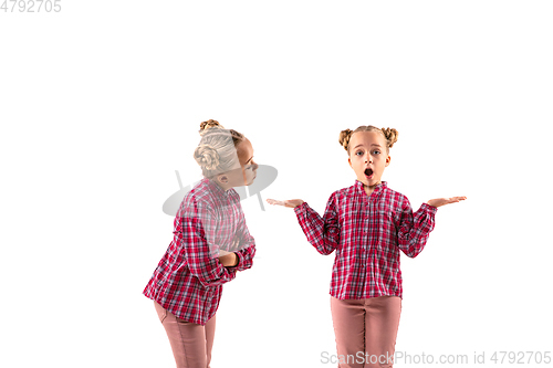 Image of Young handsome girl arguing with herself on white studio background.