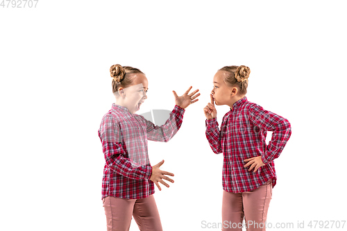 Image of Young handsome girl arguing with herself on white studio background.