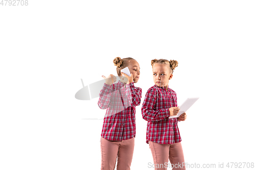 Image of Young handsome girl arguing with herself on white studio background.