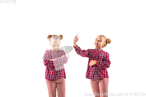 Image of Young handsome girl arguing with herself on white studio background.