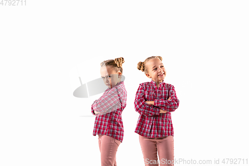 Image of Young handsome girl arguing with herself on white studio background.