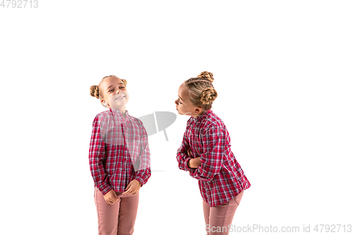 Image of Young handsome girl arguing with herself on white studio background.