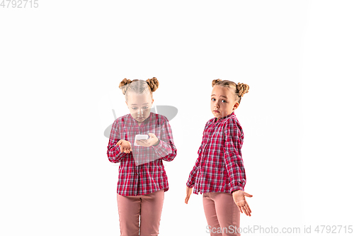 Image of Young handsome girl arguing with herself on white studio background.