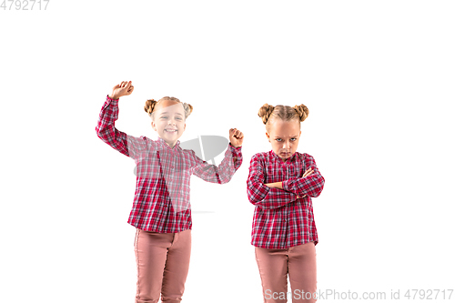 Image of Young handsome girl arguing with herself on white studio background.