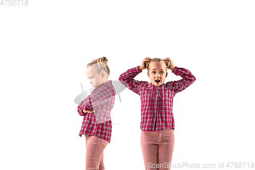 Image of Young handsome girl arguing with herself on white studio background.