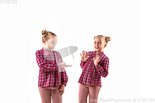 Image of Young handsome girl arguing with herself on white studio background.