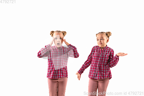 Image of Young handsome girl arguing with herself on white studio background.