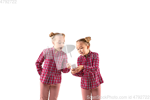 Image of Young handsome girl arguing with herself on white studio background.