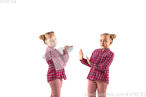 Image of Young handsome girl arguing with herself on white studio background.