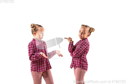 Image of Young handsome girl arguing with herself on white studio background.