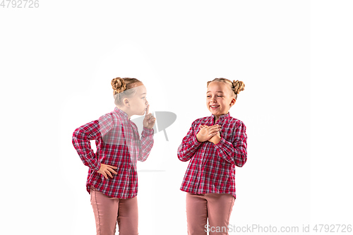 Image of Young handsome girl arguing with herself on white studio background.