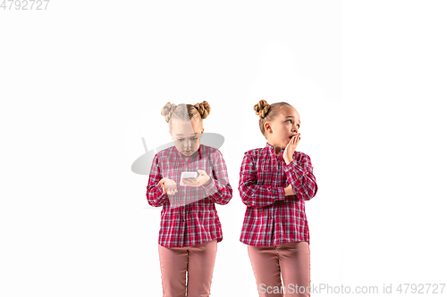 Image of Young handsome girl arguing with herself on white studio background.