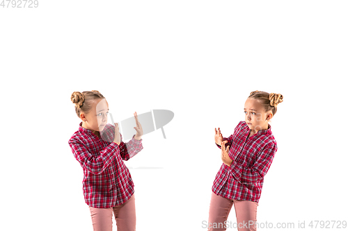 Image of Young handsome girl arguing with herself on white studio background.