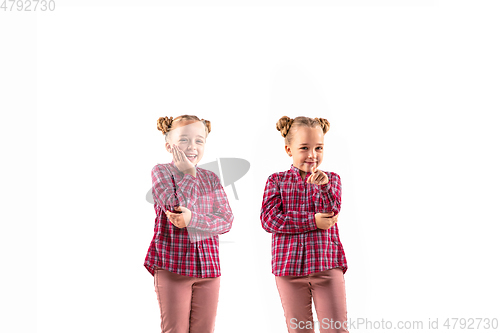 Image of Young handsome girl arguing with herself on white studio background.