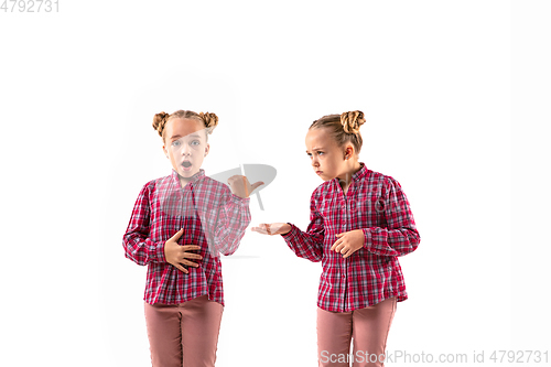 Image of Young handsome girl arguing with herself on white studio background.