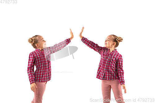 Image of Young handsome girl arguing with herself on white studio background.