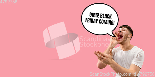 Image of Half-length close up portrait of young man on coral background with black friday lettering