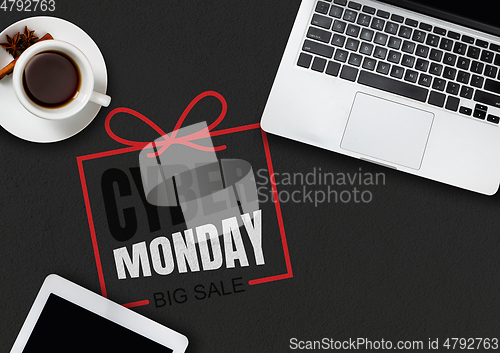 Image of Top view of laptop and cup of tea with cyber monday lettering on black background