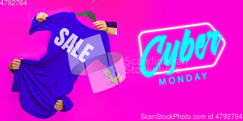 Image of Hands holding clothes with Sale lettering