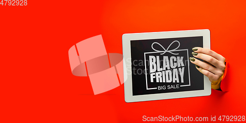 Image of Hands holding tablet screen with black friday lettering