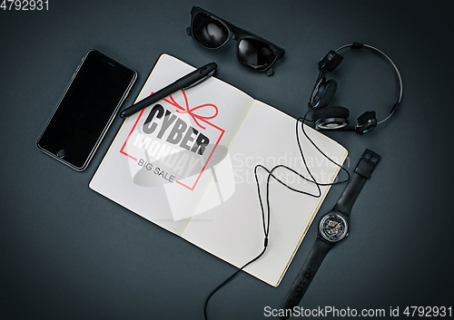 Image of Top view of gadgets with cyber monday lettering on black background