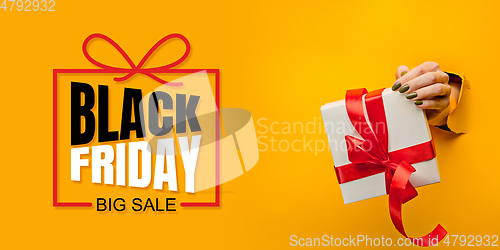 Image of Hands holding gift box with black friday lettering