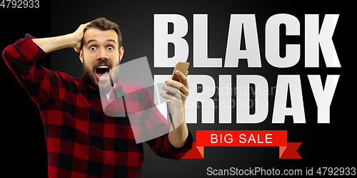 Image of Portrait of young man using smartphone, black friday