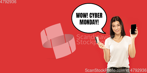 Image of Portrait of woman showing screen of mobile phone, black friday